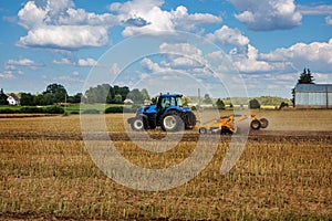 A tractor tillage of an agricultural field photo