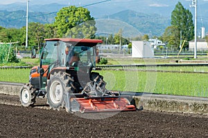 Tractor Tilling a Rice Field