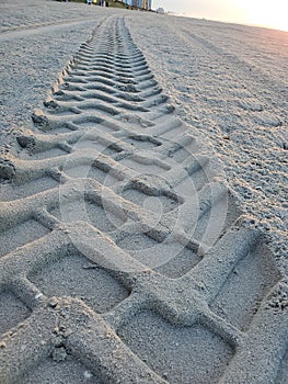 Tractor tire prints in sand at the beach