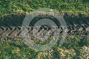 Tractor tire tracks in green grass - vintage retro look