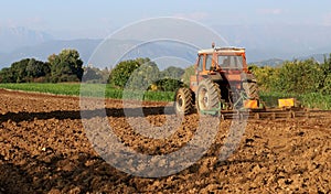 Tractor with a towed plow completes the plowing of the field before the autumn sowing