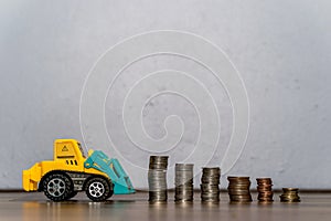 Tractor toy downloading a coins stack