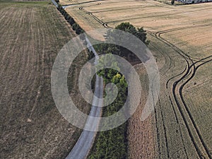 Tractor tracks in the field, Asphalt road in the mountains