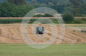 Tractor with trailer full of hay bales