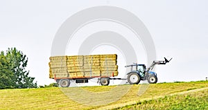 Tractor with trailer loaded with straw bales in Holland