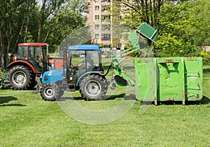 Tractor with trailer mowing grass