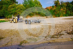 Tractor with trailer for transport boats on the sandy beach