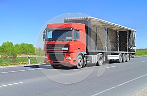 A Tractor Trailer Truck with an open trailer awnin