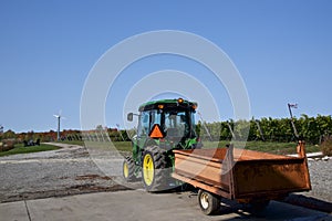 A tractor in the vineyard with rows of wine grapes in the field