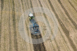 Tractor at work, cultivating a field, Seedbed cultivator Aerial