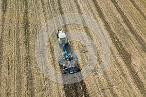 Tractor at work, cultivating a field, Seedbed cultivator Aerial View