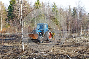 Tractor work the land among the trees
