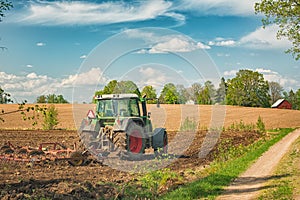 Tractor working on the farm, a modern agricultural transport, a farmer working in the field, fertile land, tractor on a sunset