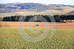 Tractor working on the farm, a modern agricultural transport, a farmer working in the field, fertile land, tractor on a sunset