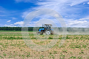 Tractor working in the field, against the blue sky