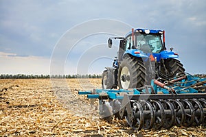 Tractor working in the field in autumn