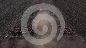 Tractor working in field at springtime aerial top view