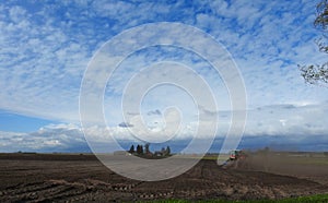 Tractor working in field windy day, Lithuania