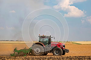 The tractor works in the field. Agricultural machine plows