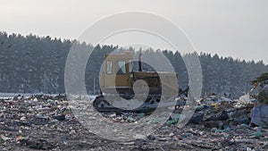 Tractor works at garbage dump in winter, Russia