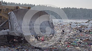 Tractor works at garbage dump in winter, Russia