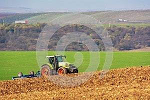 The tractor works the land. Claas Ares 836 RZ