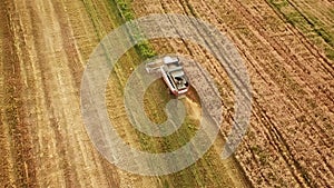 tractors and combines work.summer agricultural fields at sunset during harvest.