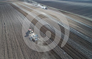 Tractors harrowing soil