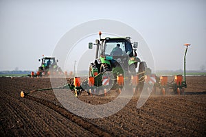 Tractors laying seeds on field