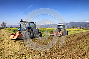 Tractors plowing a field