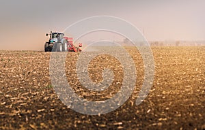 Tractors plowing stubble fields