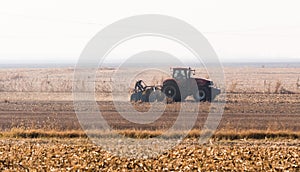 Tractors plowing stubble fields