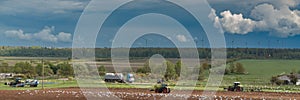 Tractors with sowers on the field in bright sunny spring morning