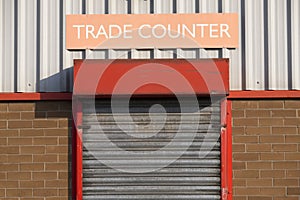 Trade counter sign above roller shutter door entrance business merchants in industrial estate