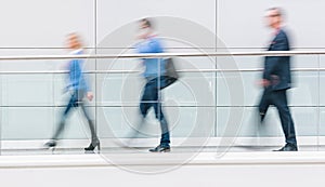 Trade fair visitors walking in a clean futuristic corridor