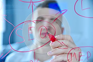 Trade worker writing SEO diagram on transparent screen