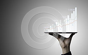 Trader holding Tablet and touching to technical graph chart  for analysis stock market data and speculator investment concept