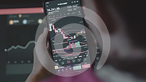 Trader investor analyst using mobile phone app and computer. Analytics for cryptocurrency financial stock market