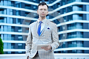 Trader man in suit holding digital tablet computer