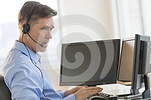 Trader Using Multiple Computer Screens While Communicating Through Headphones