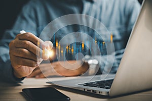 Trader utilizing technology to analyze candlestick chart, making informed stock market trades