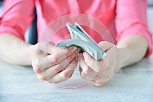 Trader woman counting dollars at table