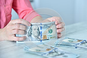 Trader woman holding dollars at table