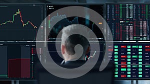 Trader is working with multiple computer screens full of charts and data analysis and stock broker trading online. Back