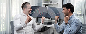 Traders raising fist up in stock achievement with panorama view. Sellable.