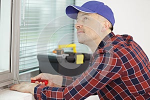 tradesman installing new window blinds