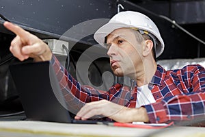 tradesman in roof space pointing forwards