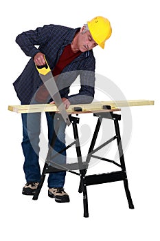Tradesman sawing a plank