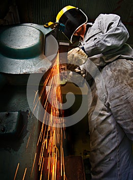 Tradesman at work grinding steel.