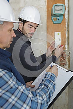 Tradesmen installing distribution board